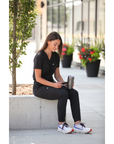 Woman Texting in Real Black Women's Tuckable One-Pocket Scrub Top and Perfect Joggers