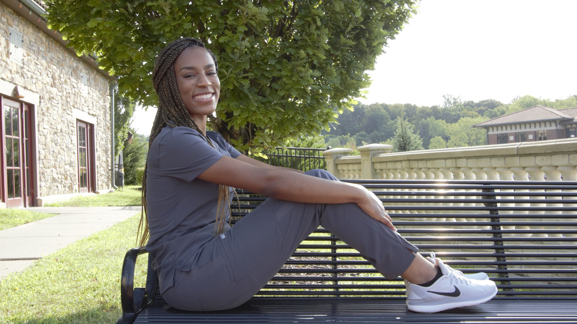 Woman in Charcoal Gray Stretch Collection Scrubs on Hospital Bench