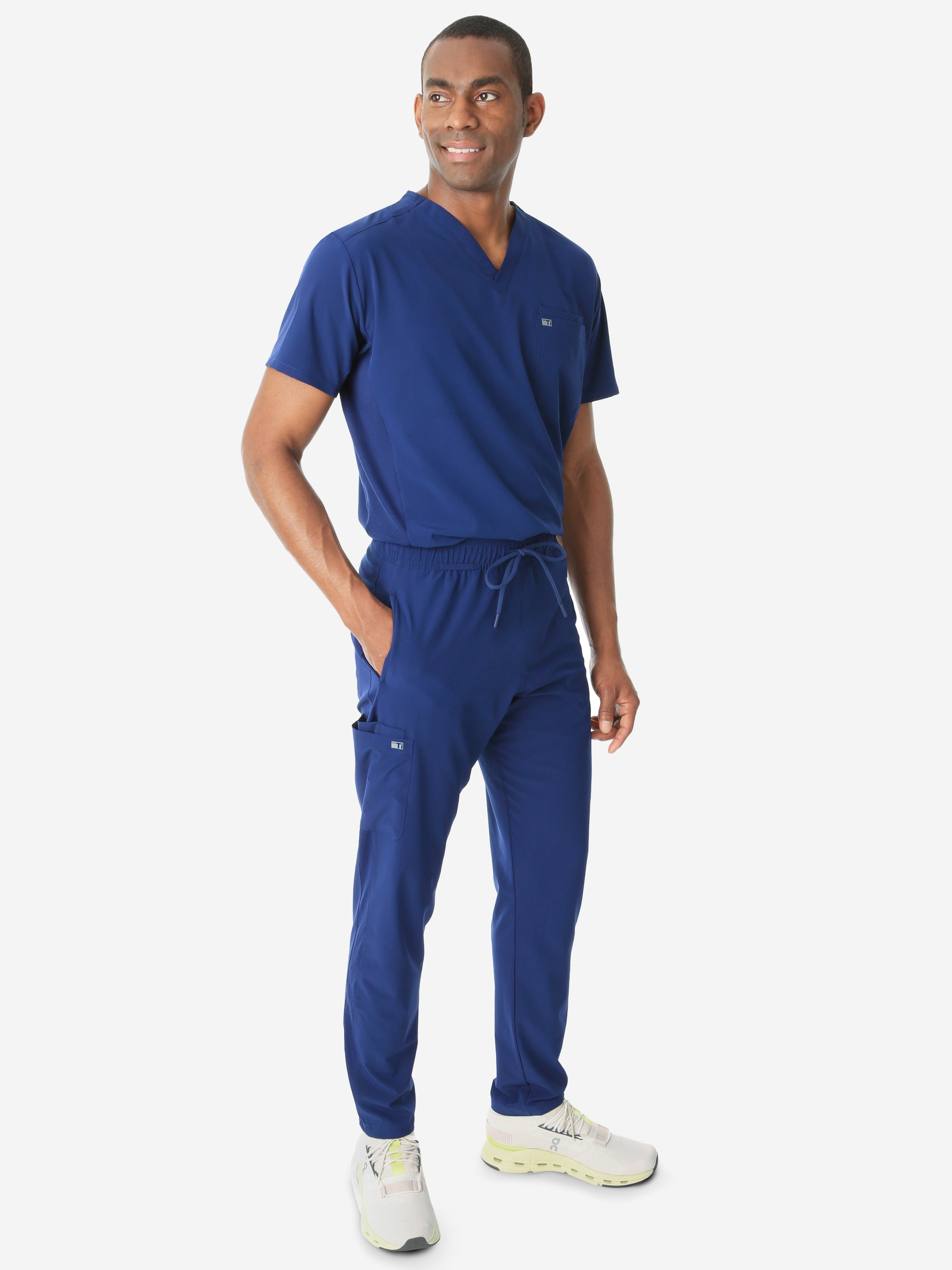 Men's Double-Pocket Scrub Top Navy Blue Tucked Side View with 9-Pocket Pants