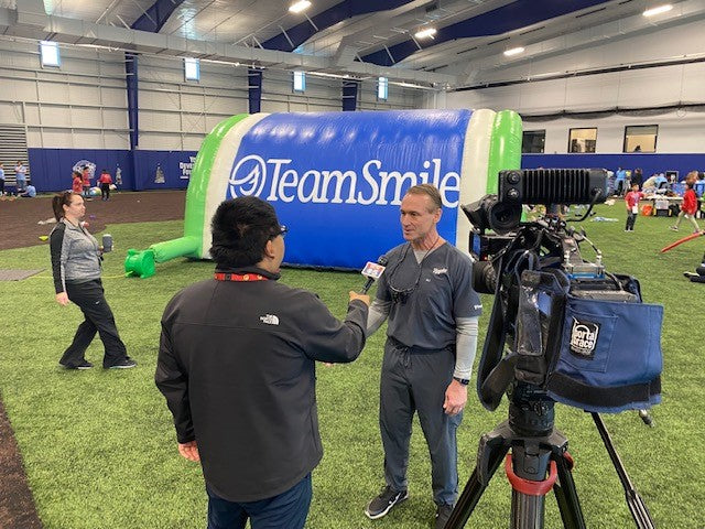 Dr. Bill Busch wearing embroidered TiScrubs at a TeamSmile dental outreach event with the Kansas City Royals