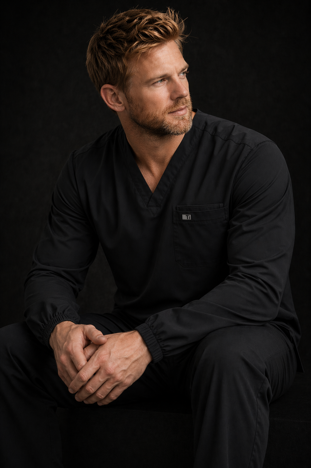 Male healthcare professional wearing black TiScrubs long sleeve scrub top