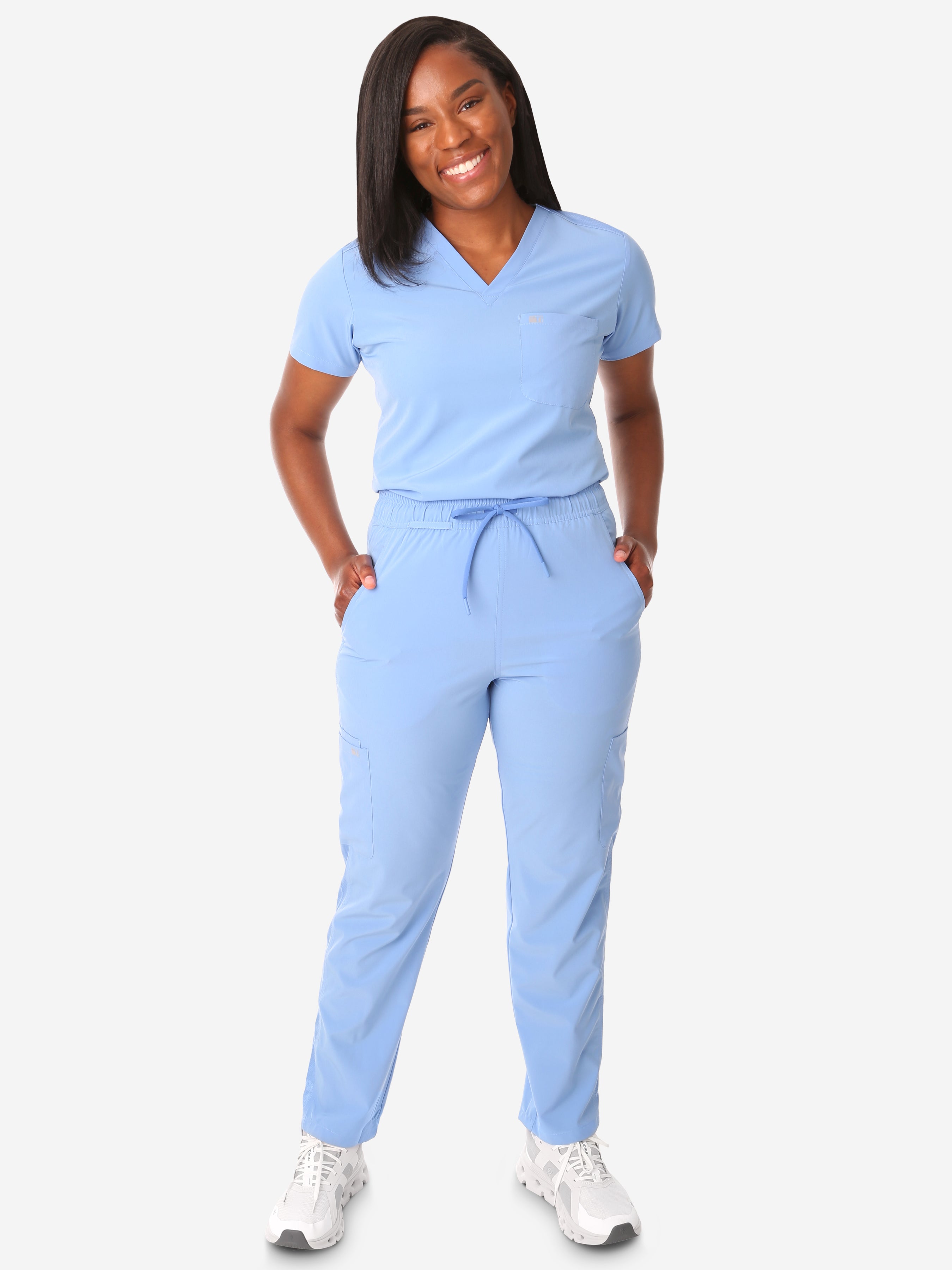 TiScrubs Women&#39;s Stretch Ceil Blue One-Pocket Tuckable Scrub Top and 9-Pocket Pants Tucked  Full Body Front