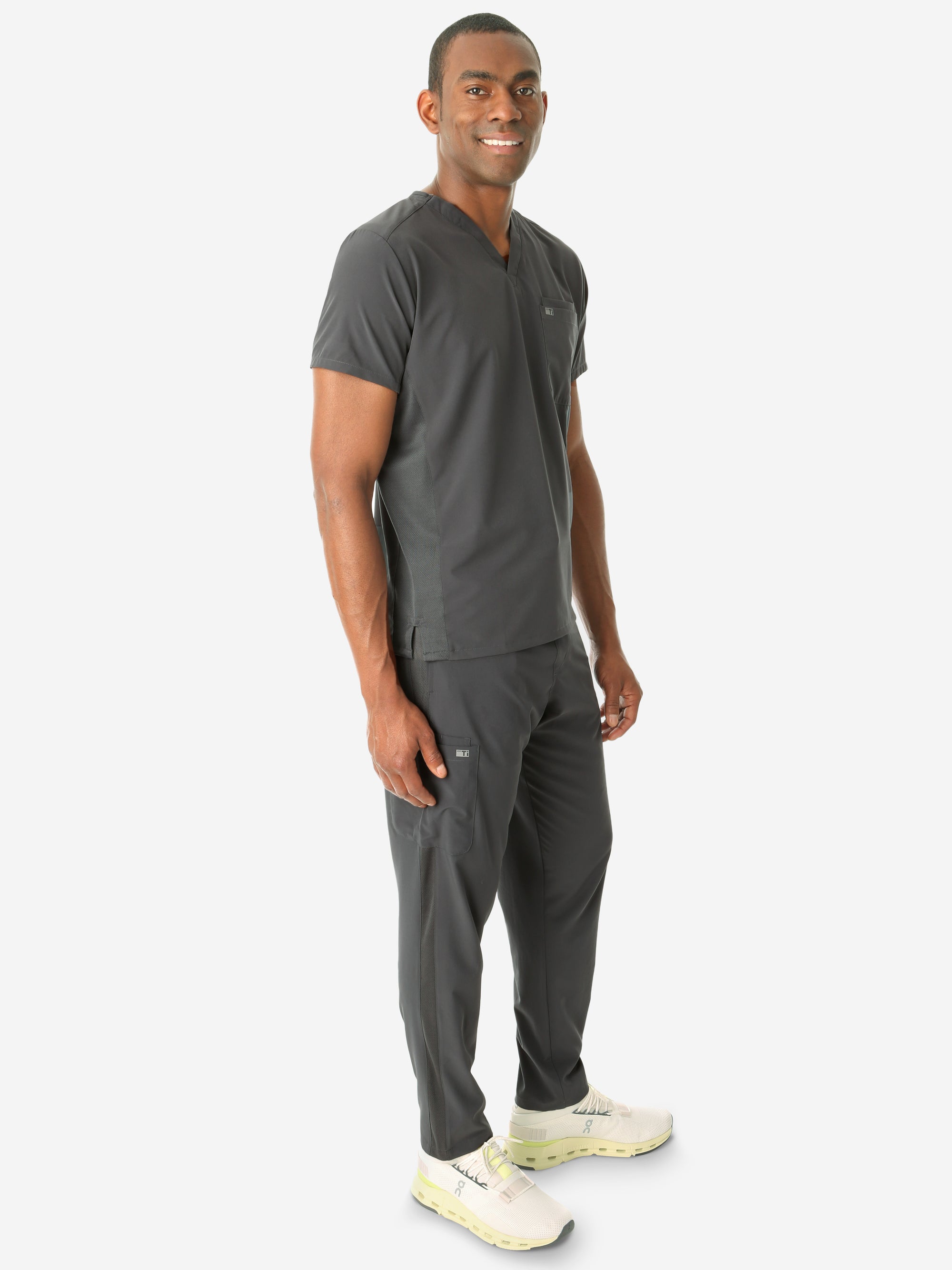 Men&#39;s Double Pocket Scrub Top Untucked Charcoal Gray Full Body Side View with 9-Pocket Pants