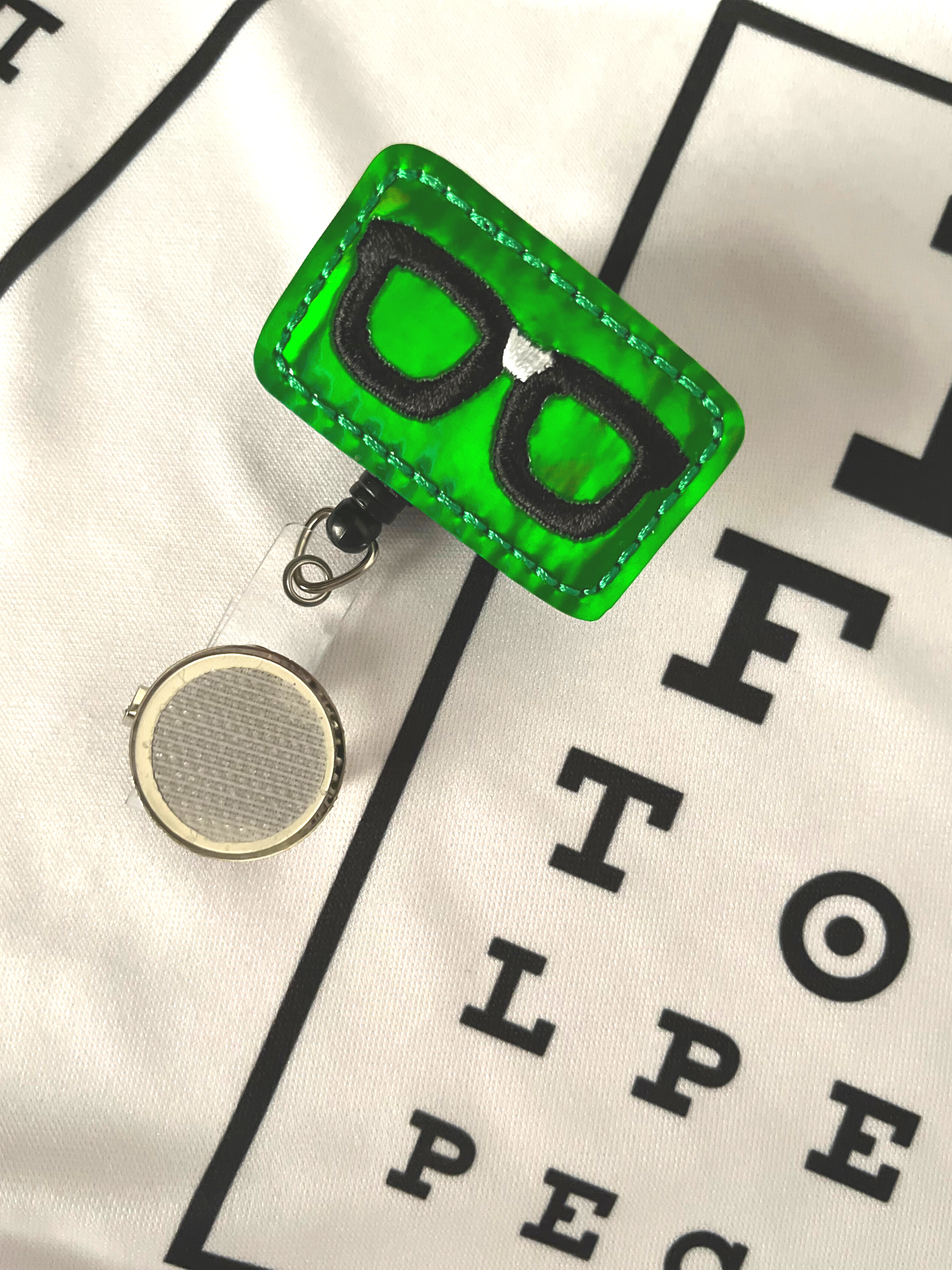 Green Glasses Badge Reel Accessory on White 20/20 Vision Scrub Top