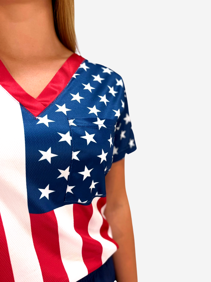 Women&#39;s American Flag Patriotic scrub top on model pocket closeup