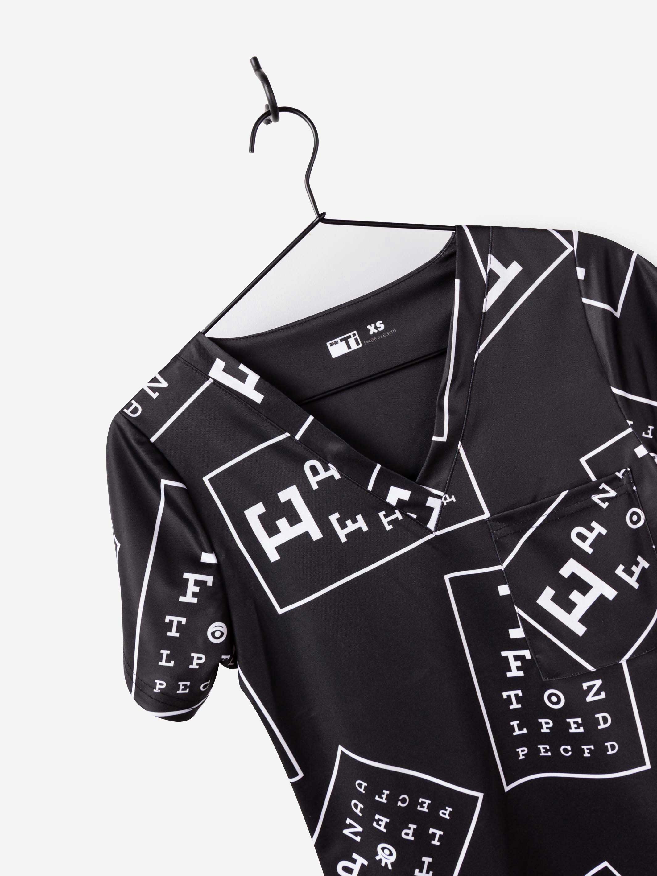 women's ophthalmology print scrub top black with white eye charts v-neck