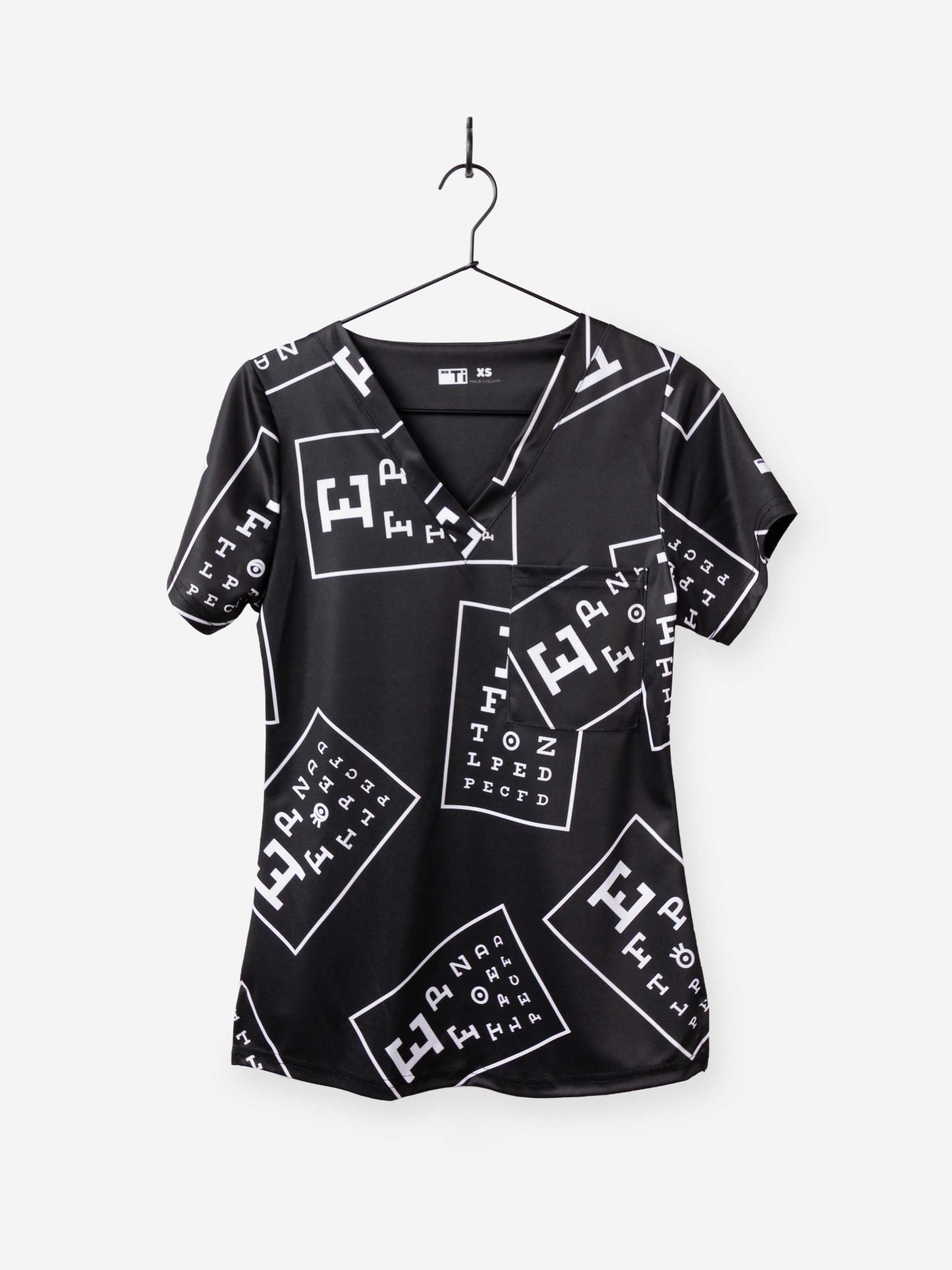 women's ophthalmology print scrub top black with white eye charts chest pocket